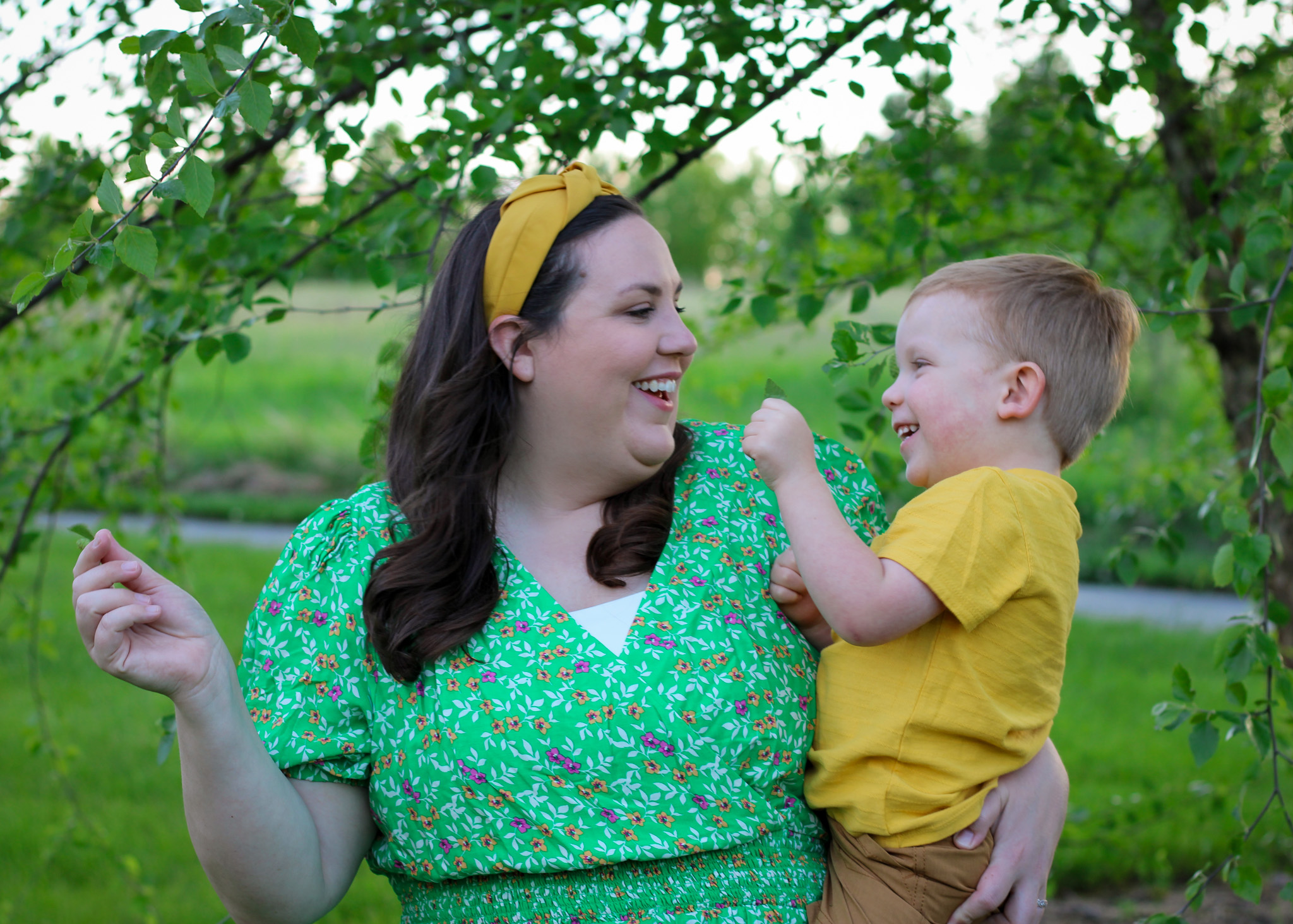 mom and son playing smiling candid outdoor green leaves tree photo