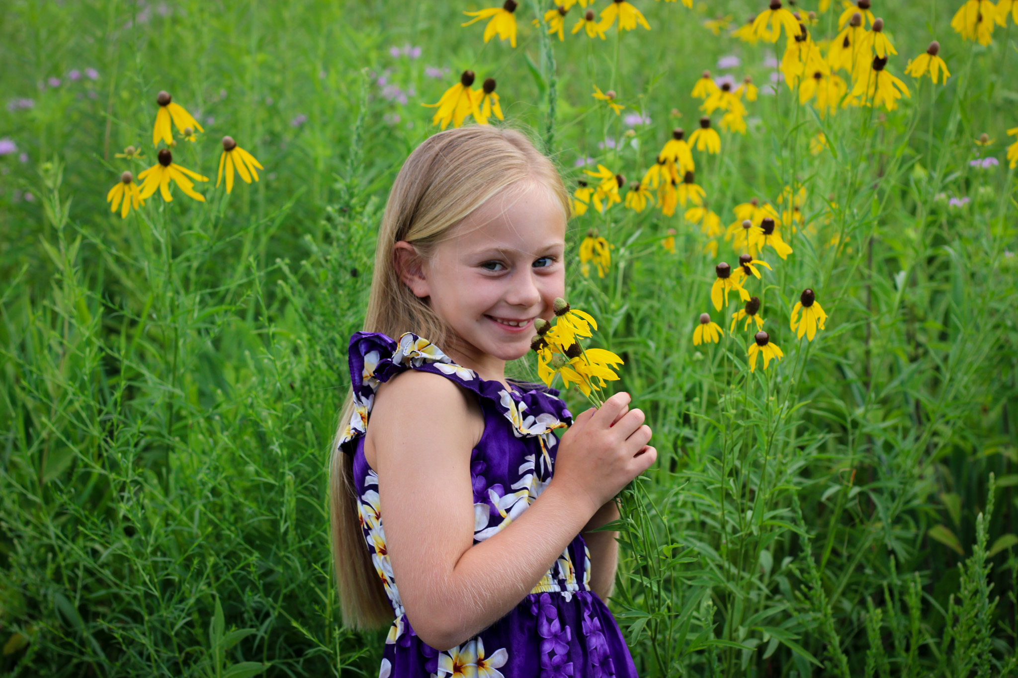 girl smelling flowers and smiling outdoor photo