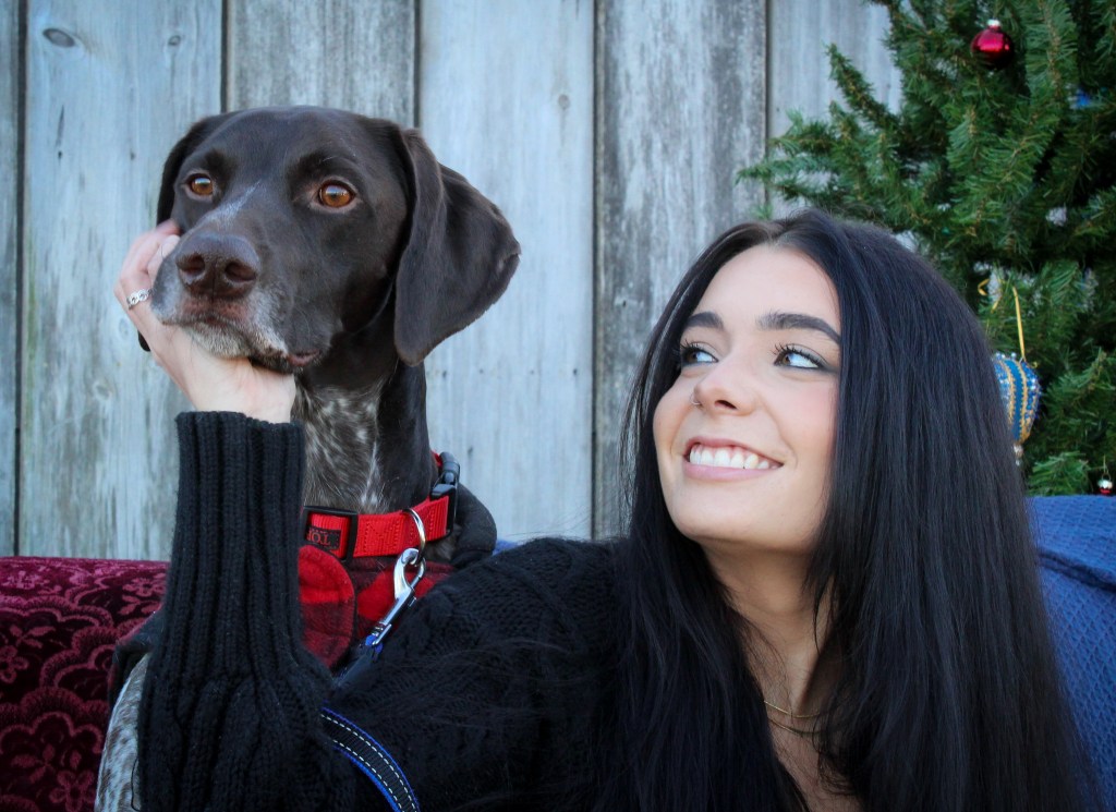 Woman smiling adorably at distracted dog outdoor barn photo